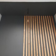 Процесс монтажа деревянных реек на стену в кухне